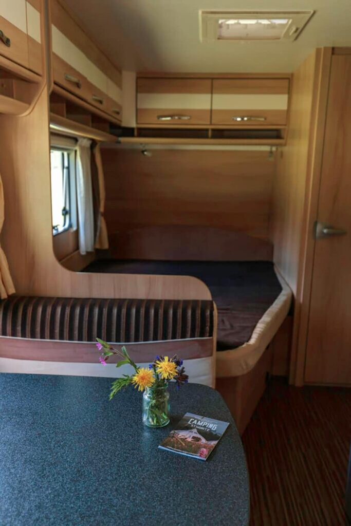 Der Mietwohnwagen verfügt eine komfortable Ausstattung, ein großes Bett und ein Esstisch mit viel Platz.